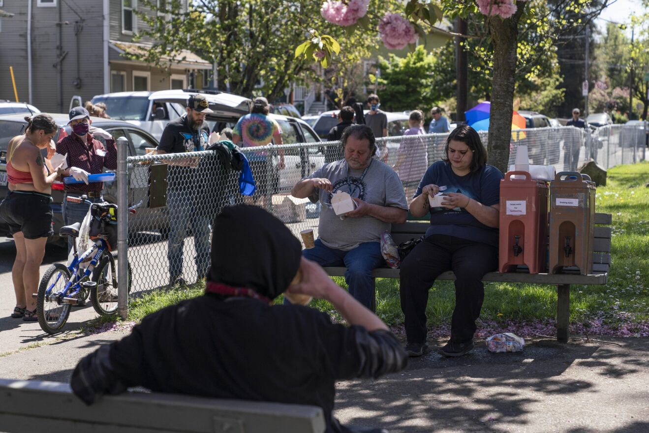 Mercedes Moreno, right, enjoys a free lunch that is distributed to people who need it in Southeast Portland's Sunnyside Park.